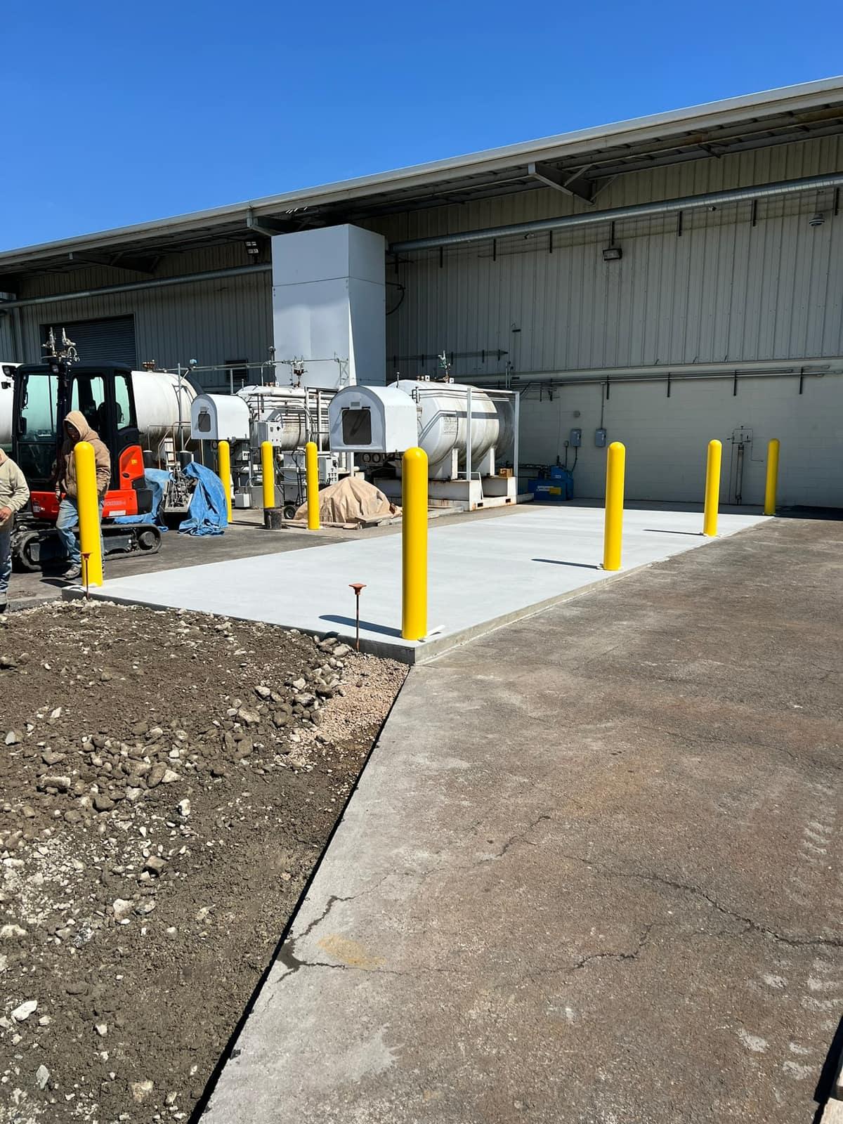 Finished equipment pad with protective bollards by MJS & Sons Construction