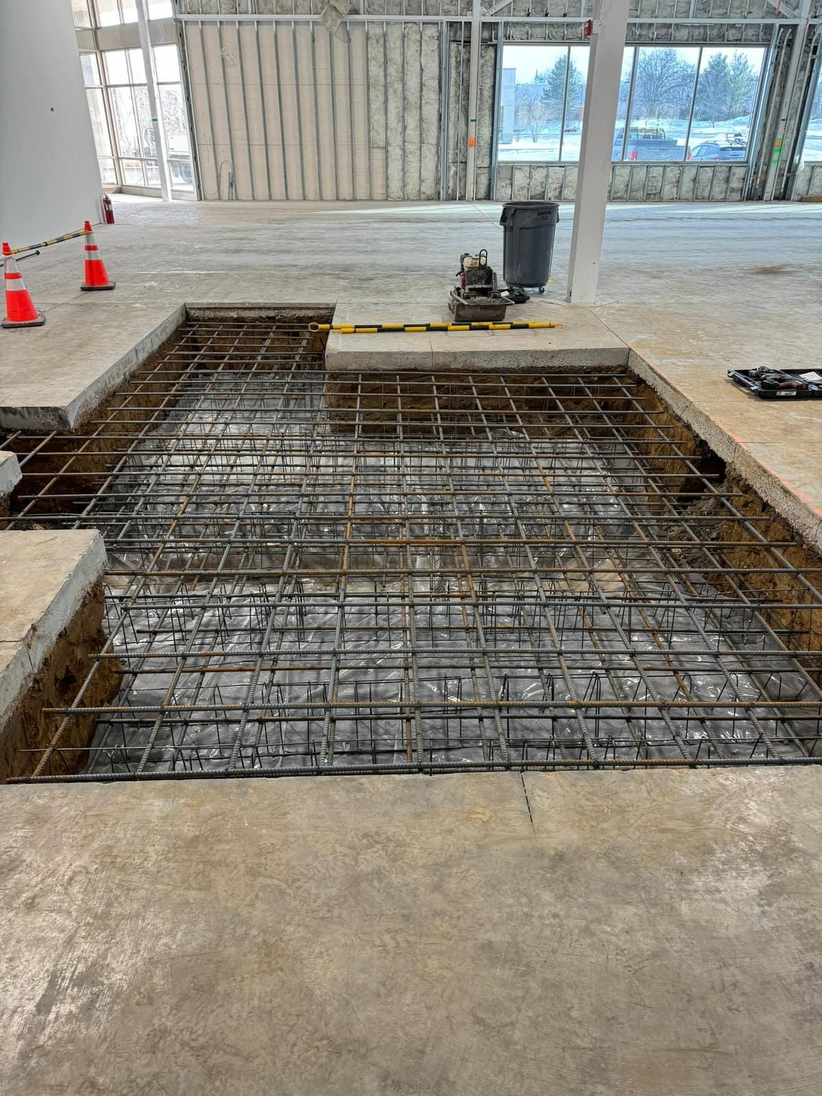 Open foundation pit with a full-depth rebar mat by MJS & Sons Construction